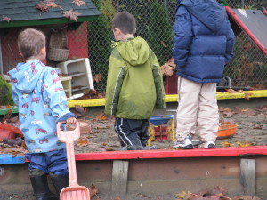 S & R walk over to the sandbox and return to the puddle with one more shovel.